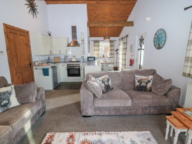 A living room and kitchen area with two sofas and a dining table at Matfen in Longframlington