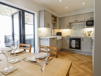 A kitchen with cabinets and appliances at Neptune Cottage in Conwy