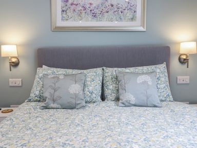A bedroom with a bed and decorative pillows at Neptune Cottage in Conwy