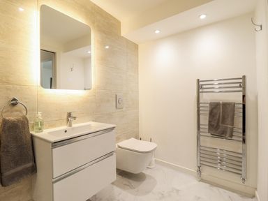 A bathroom with a sink and towel rack at Neptune Cottage in Conwy
