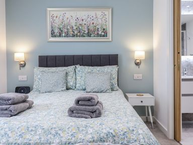 A bedroom with a bed and bedside table at Neptune Cottage in Conwy
