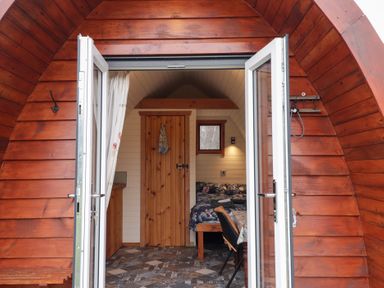 A pod with a bed and table at Pod 2 in Beauly