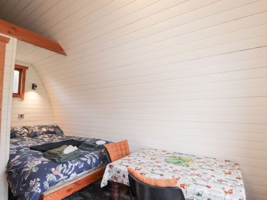 A bedroom with a bed and a table in Pod 2 Beauly