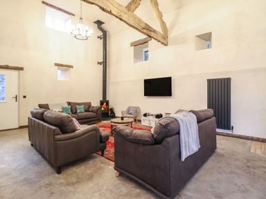 A living room with sofas and a fireplace at Godre'r Gyrn, Plas Moelfre Hall Barns in Oswestry