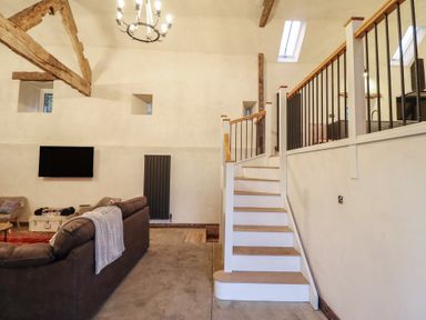 A living room with a sofa and television at Godre'r Gyrn, Plas Moelfre Hall Barns, Oswestry