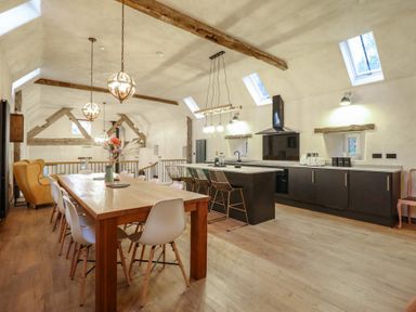 A kitchen with a dining table and chairs at Godre'r Gyrn, Plas Moelfre Hall Barns in Oswestry