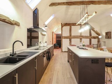 A kitchen with a countertop and appliances at Godre'r Gyrn, Plas Moelfre Hall Barns, Oswestry