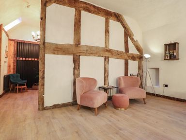 A living room with two chairs and a small table at Godre'r Gyrn, Plas Moelfre Hall Barns in Oswestry