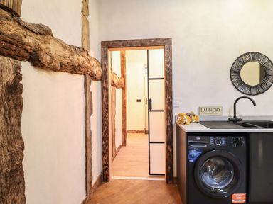 A laundry room with a washing machine and sink at Godre'r Gyrn, Plas Moelfre Hall Barns in Oswestry