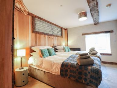 A bedroom with double beds and towels arranged at Godre'r Gyrn, Plas Moelfre Hall Barns, Oswestry