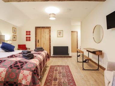 A bedroom with a bed, towels, and a side table at Godre'r Gyrn, Plas Moelfre Hall Barns in Oswestry