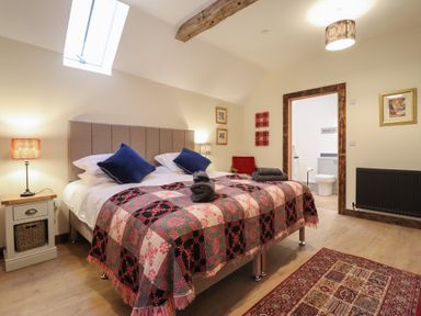 A bedroom with a bed and lamp at Godre'r Gyrn, Plas Moelfre Hall Barns Oswestry
