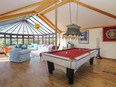 A games room with a pool table seating area and dartboard at Beach Haven in Happisburgh East Anglia