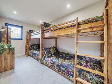 A bedroom with two wooden bunk beds and floral bedding at Micklemore Lakes and Lodges in North Thoresby