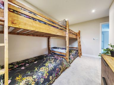 A bedroom with wooden bunk beds and floral bedding at Micklemore Lakes and Lodges in North Thoresby