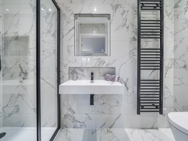 A bathroom with a wall-mounted sink towel radiator and a shower enclosure at Micklemore Lakes and Lodges in North Thoresby