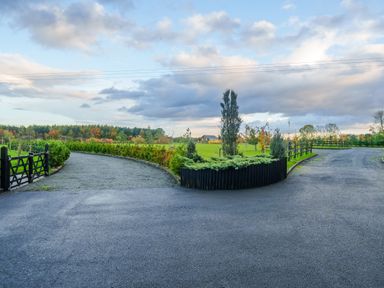 A split driveway with gravel paths surrounded by greenery and trees at Micklemore Lakes and Lodges in North Thoresby