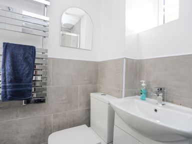 A bathroom with a toilet sink mirror towel on heated rail at 4 Ty Person in Braichmelyn near Bethesda