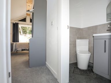 A hallway with a view of a bedroom on the left and a bathroom with a toilet on the right at 4 Ty Person in Braichmelyn near Bethesda