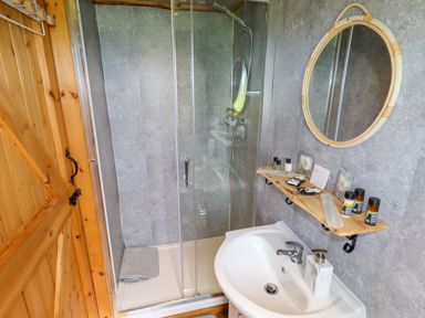 A bathroom with a sink mirror and glass shower at Moel Y Parc in Bryniau Clwyd near Denbigh