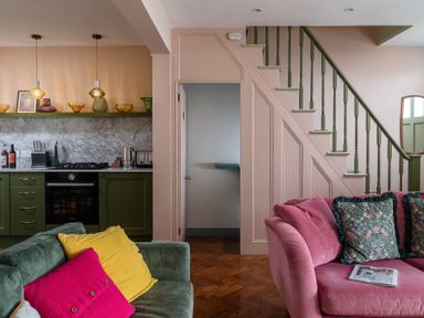 A living room with a kitchen area and staircase at Astondene, East Cliff, Southwold