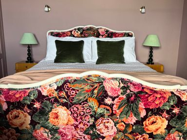 A bedroom with a floral bed at Astondene, East Cliff, Southwold