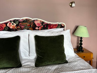 A bedroom featuring a bed with pillows and a lamp at Astondene, East Cliff, Southwold