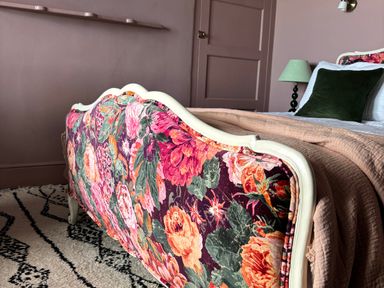 A bedroom with a floral bed at Astondene, East Cliff Southwold