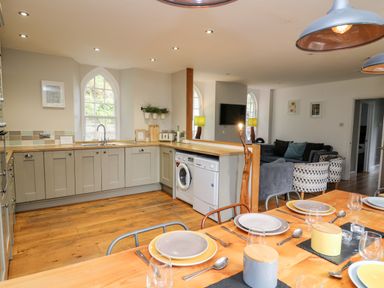 A kitchen and dining area with wooden floors and counter at Upper Vestry in Llangrannog