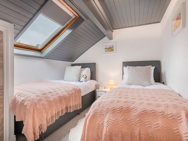 A bedroom with two single beds and a skylight window at The Waterfall Retreat in Orton