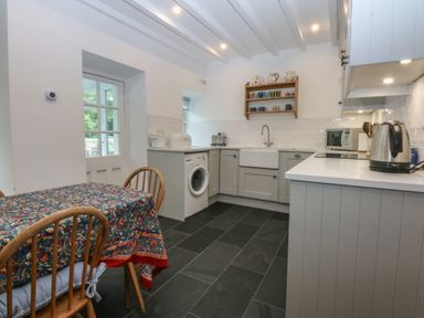 A kitchen with a table and appliances at Chandos in Dolwyddelan