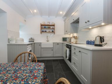 A kitchen with appliances and a dining table at Chandos in Dolwyddelan