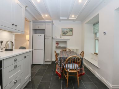 A kitchen with a table and chairs at Chandos in Dolwyddelan