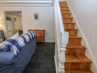 A living room with staircase and sofa at Chandos in Dolwyddelan