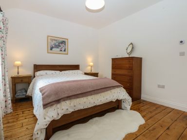 A bedroom with a bed and dresser at Chandos in Dolwyddelan