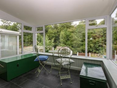 A sunroom with chairs and a table at Chandos in Dolwyddelan