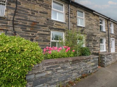 A house with stone wall and flowers at Chandos in Dolwyddelan