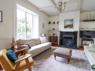 A living room with sofas a fireplace a television and a window at Charmouth Lodge in Charmouth