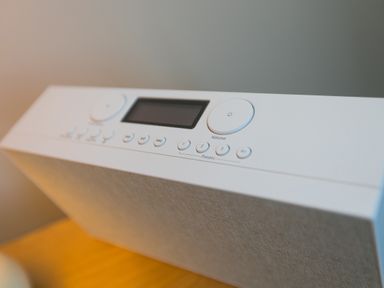 A white speaker with control buttons and a display on top on a wooden surface at Wavetop in Carbis Bay
