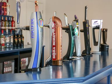 A bar counter with multiple beer taps and bottles of liquor in the background at Silverdale View East Heslerton near Sherburn