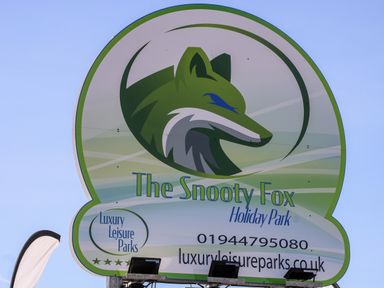 A sign for The Snooty Fox Holiday Park with a fox logo and contact information at Luxury Leisure Parks