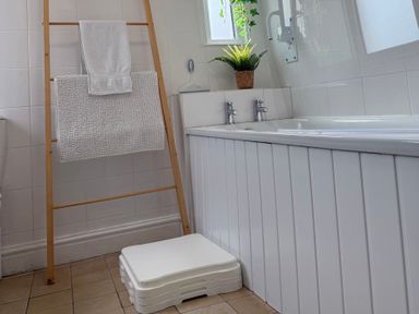 A bathroom with a toilet, sink, and bath at Waves End in Mevagissey