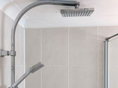 A shower area with a fixed overhead showerhead and a handheld showerhead at The Gables Penthouse in Bournemouth