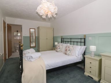 A bedroom with a bed and wardrobe at Wingelock in Rhosneigr