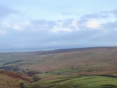 A rural landscape with hills fields and scattered buildings at The Byre in Carrshield near Allendale