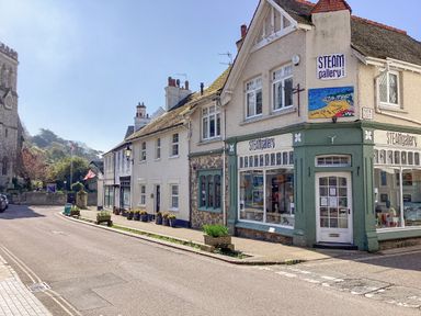 A street view with buildings including a gallery and a church at The Old Lace Shop in Beer