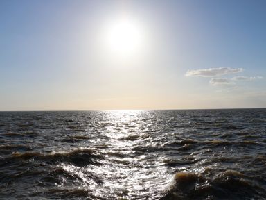 A view of the sun shining over the ocean with small clouds in the sky at 5a Hideaways in Hunstanton