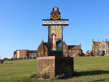 A town sign reading Hunstanton on a grass area with buildings in the background at 5a Hideaways Hunstanton