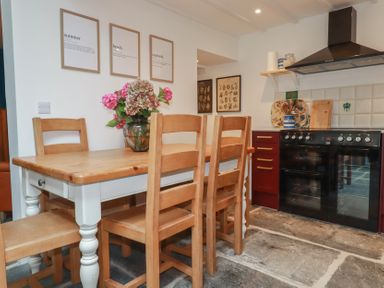 A kitchen with a dining table and chairs at 84 Fore Street