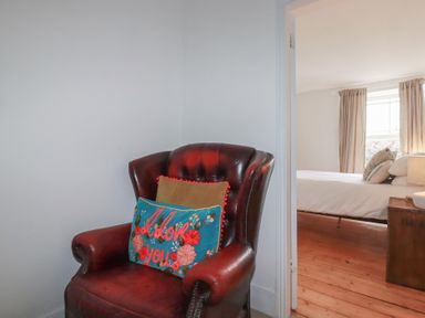 An armchair with a cushion in a bedroom at 84 Fore Street